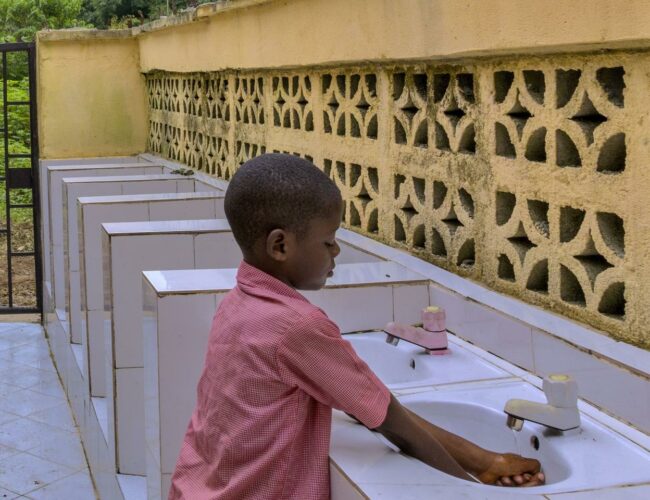 Pupil washing and sanitizing their hands on resumption Day