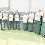 Students of I Scholars International Academy holding copies of Teen Trust