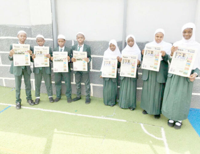 Students of I Scholars International Academy holding copies of Teen Trust