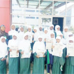 Student of I-Scholars International Academy, Gwarinpa, displaying copies of Teen Trust, during their visit to Media Trust Group Abuja