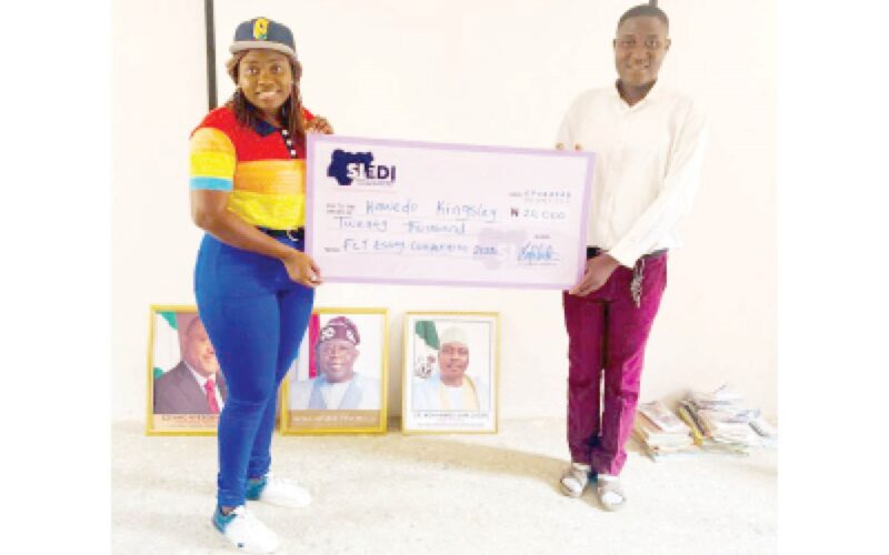 The winner, Kawedo Kingsley being presented a cheque