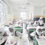 Students of I scholars International Academy reading Teen Trust Newspaper