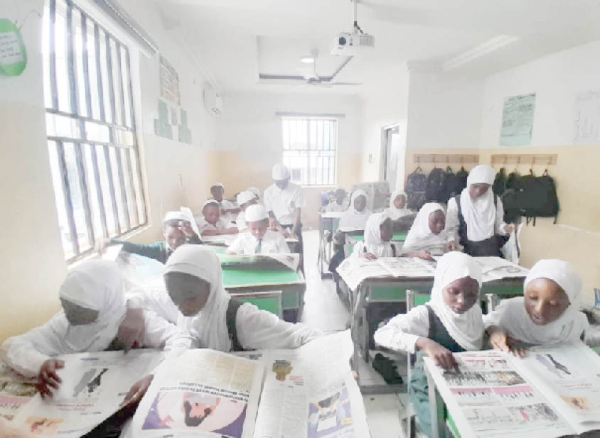 Students of I scholars International Academy reading Teen Trust Newspaper